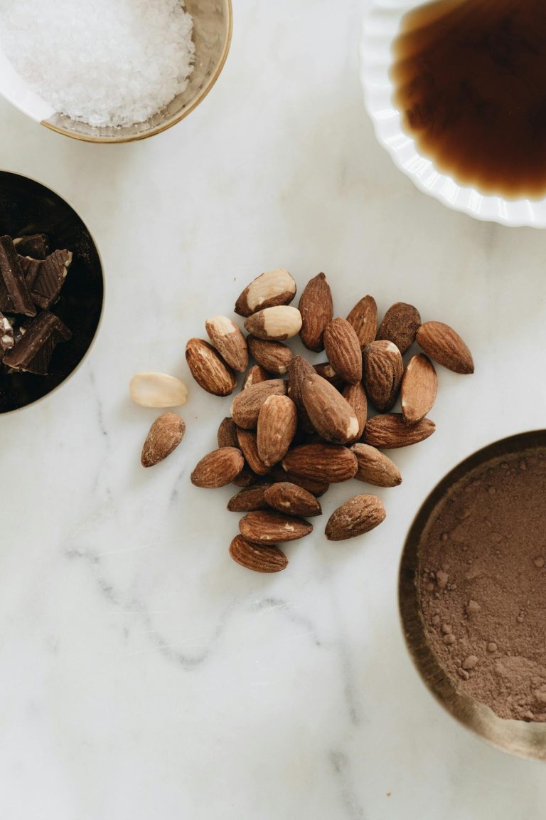 A tantalizing display of almonds with cacao and chocolate ingredients on a marble surface.